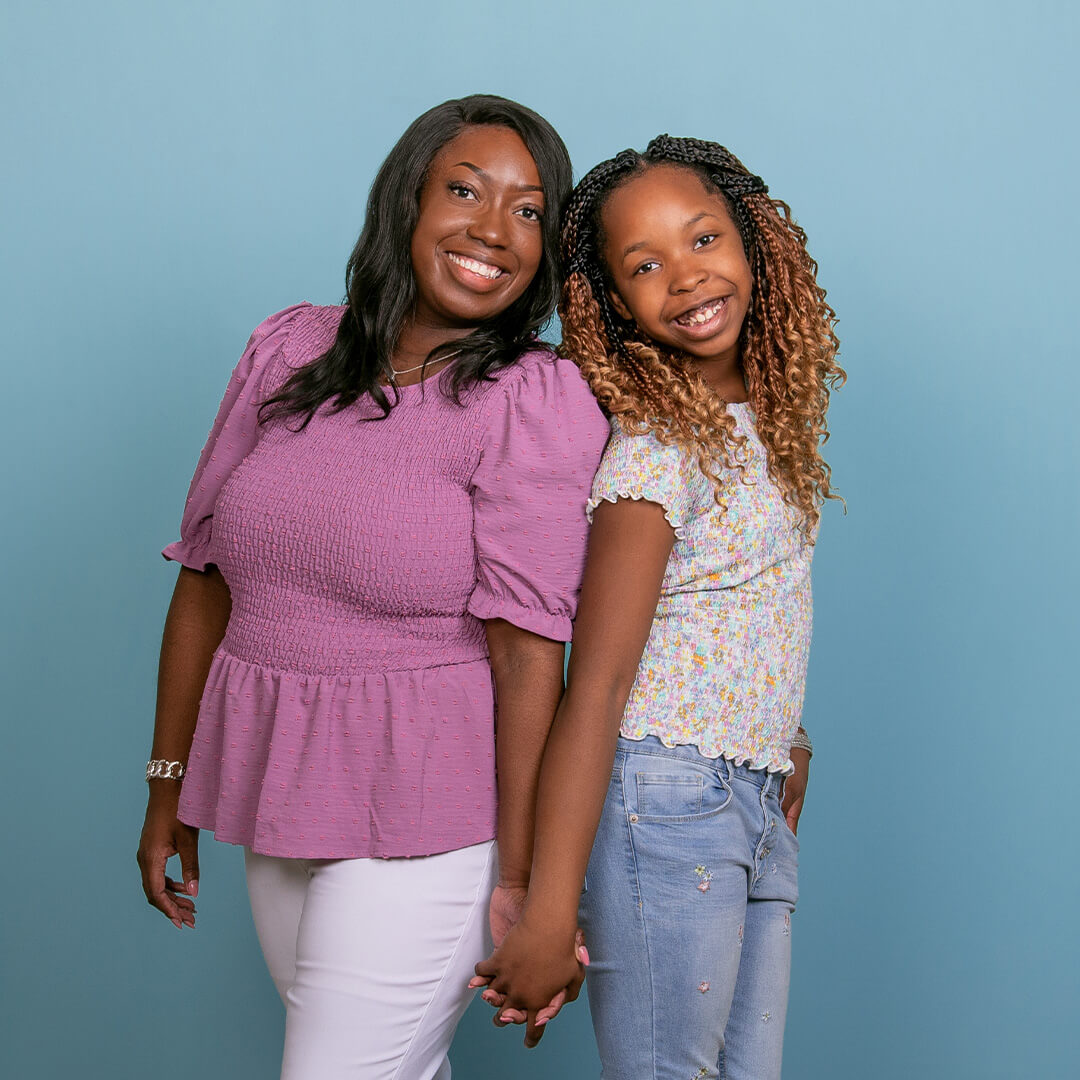 Mother and daughter posing for pictures on a blue background