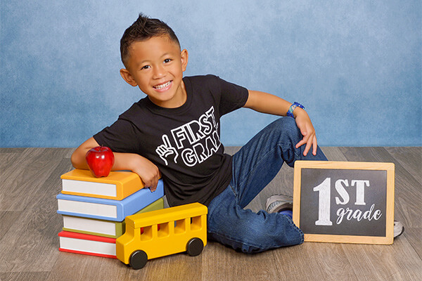 Boy posing with school props for a back to school photoshoot.