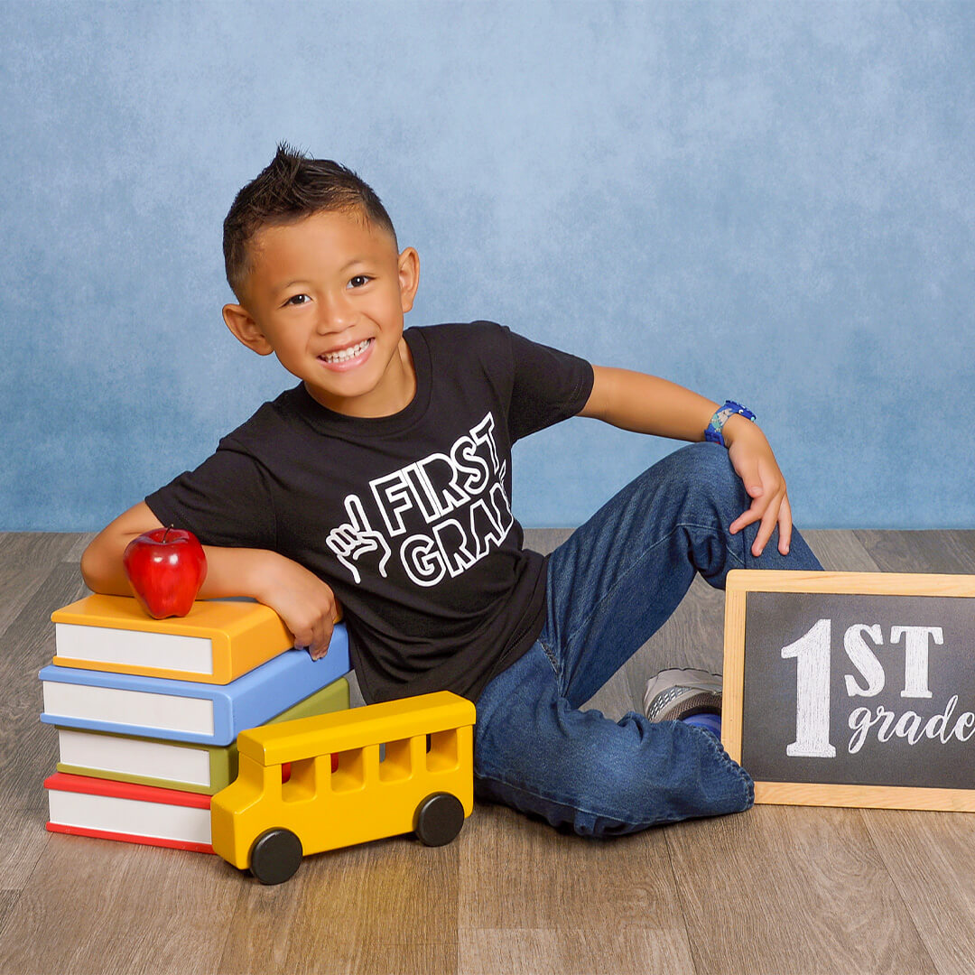 Boy posing with school props for a back to school photoshoot.