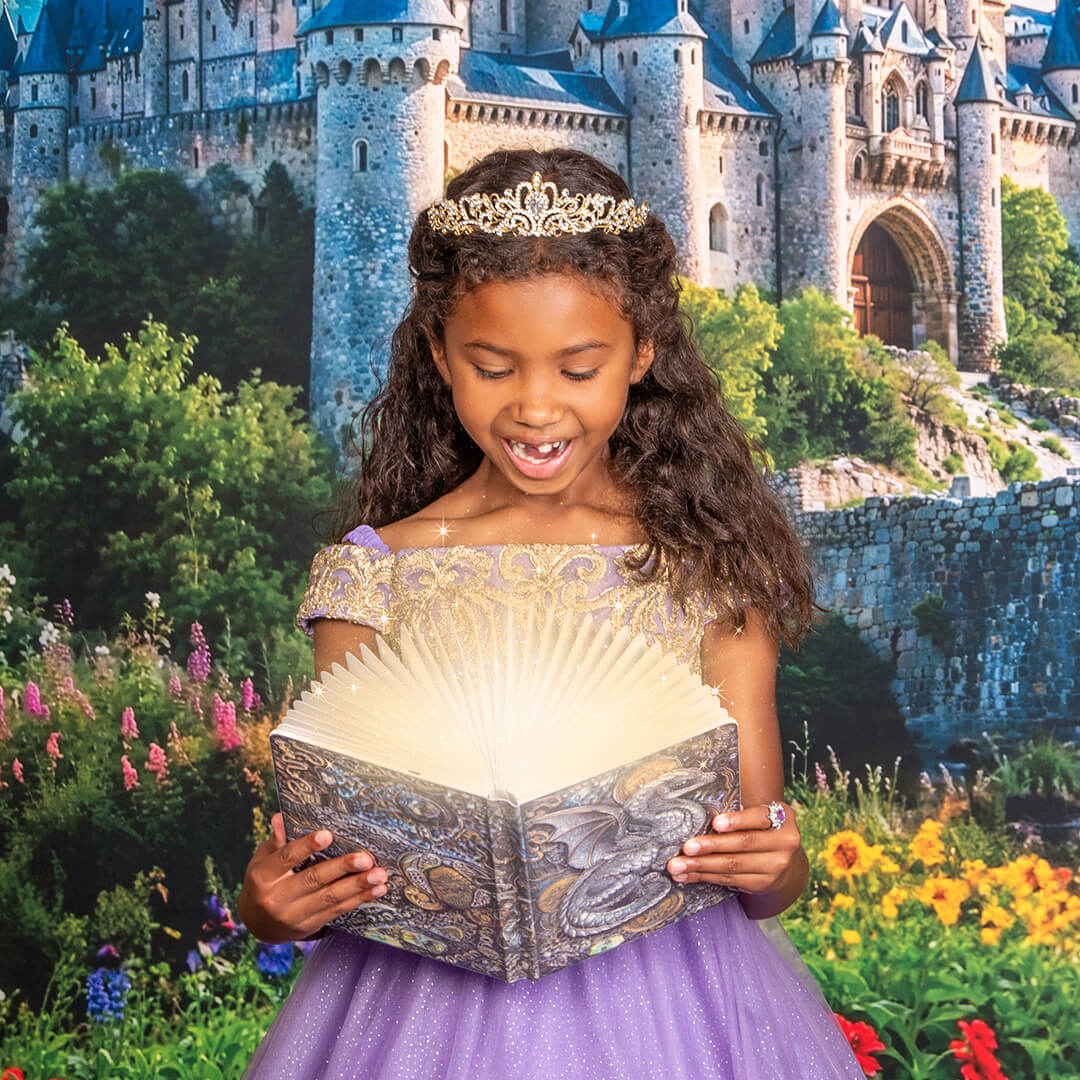 Girl in a purple princess gown holding a book.