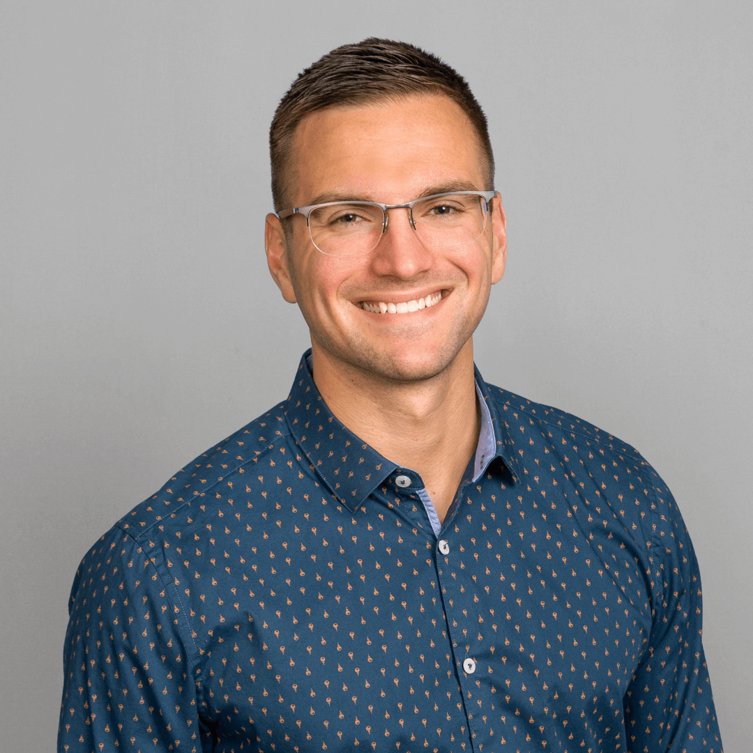 Man in a blue button down shirt posing for business headshots.