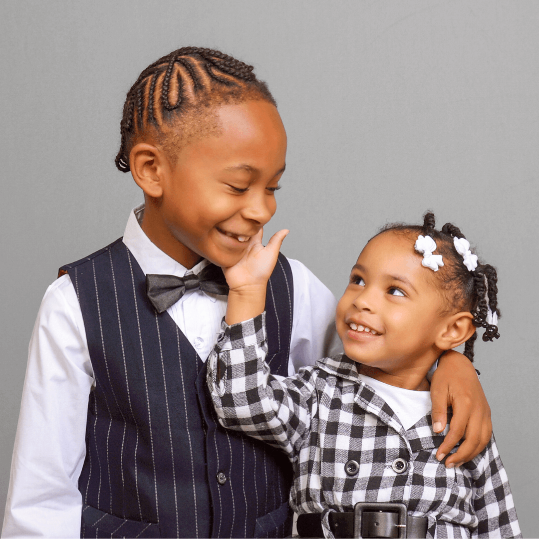 Girl touching her brothers face, posing for pictures.