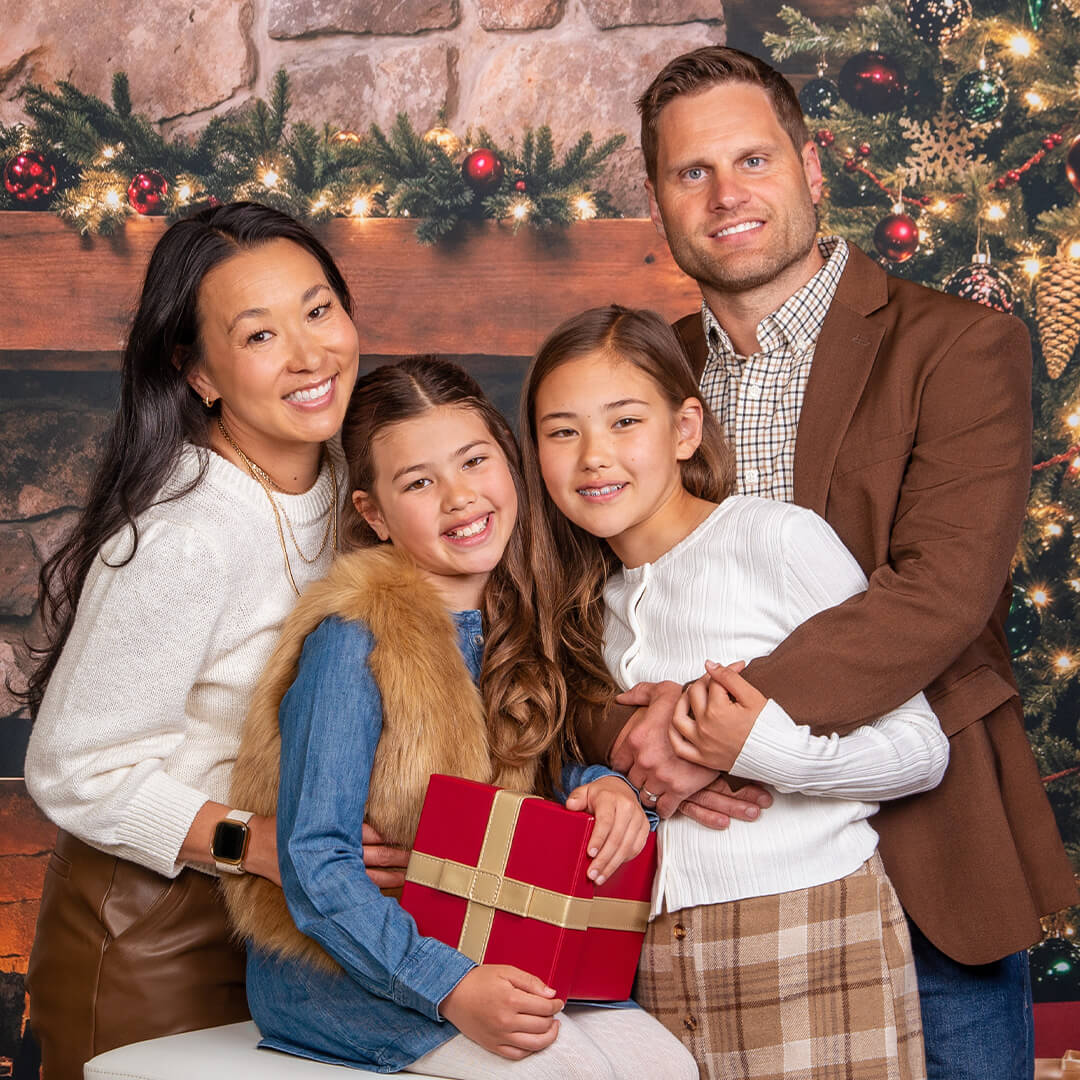 Family of four posing for holiday and Christmas photos.