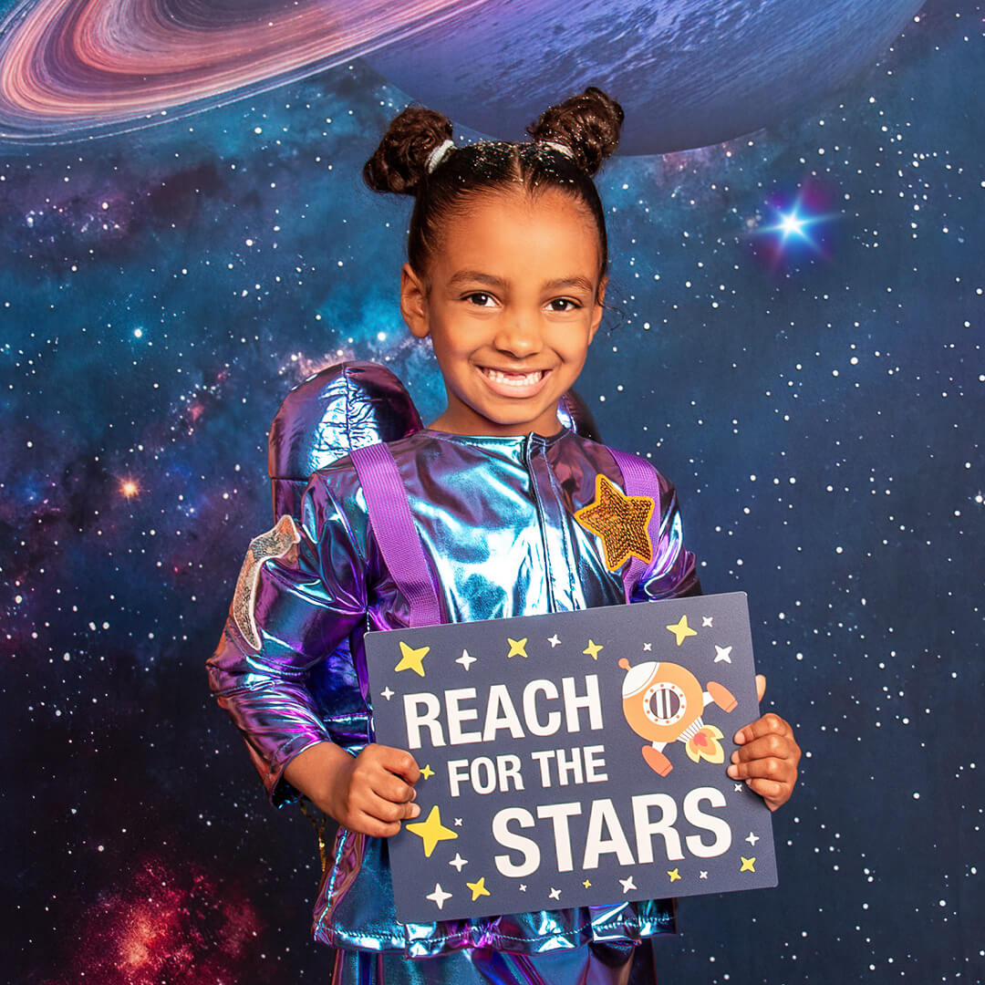 Girl holding a sign prop for space photos.