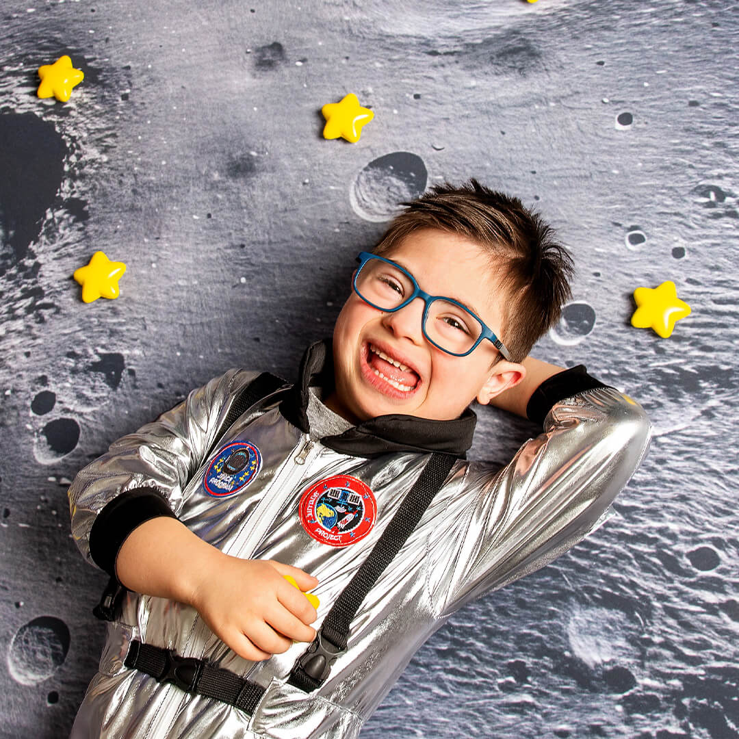 Boy posing on the moon backdrop for space pictures.