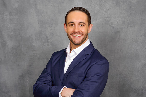 Man in a blue suit posing for business headshot photos.