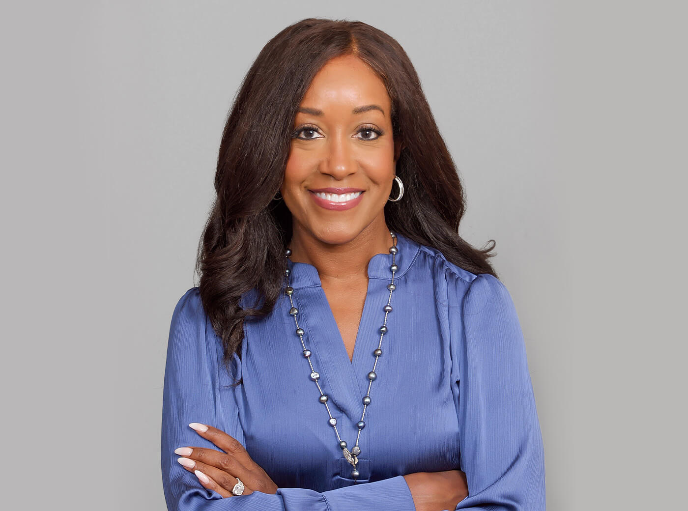 Woman in a blue blouse smiling for professional business photos.