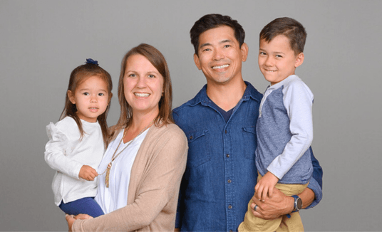 Family of four in coordinating outfits for professional family photos.