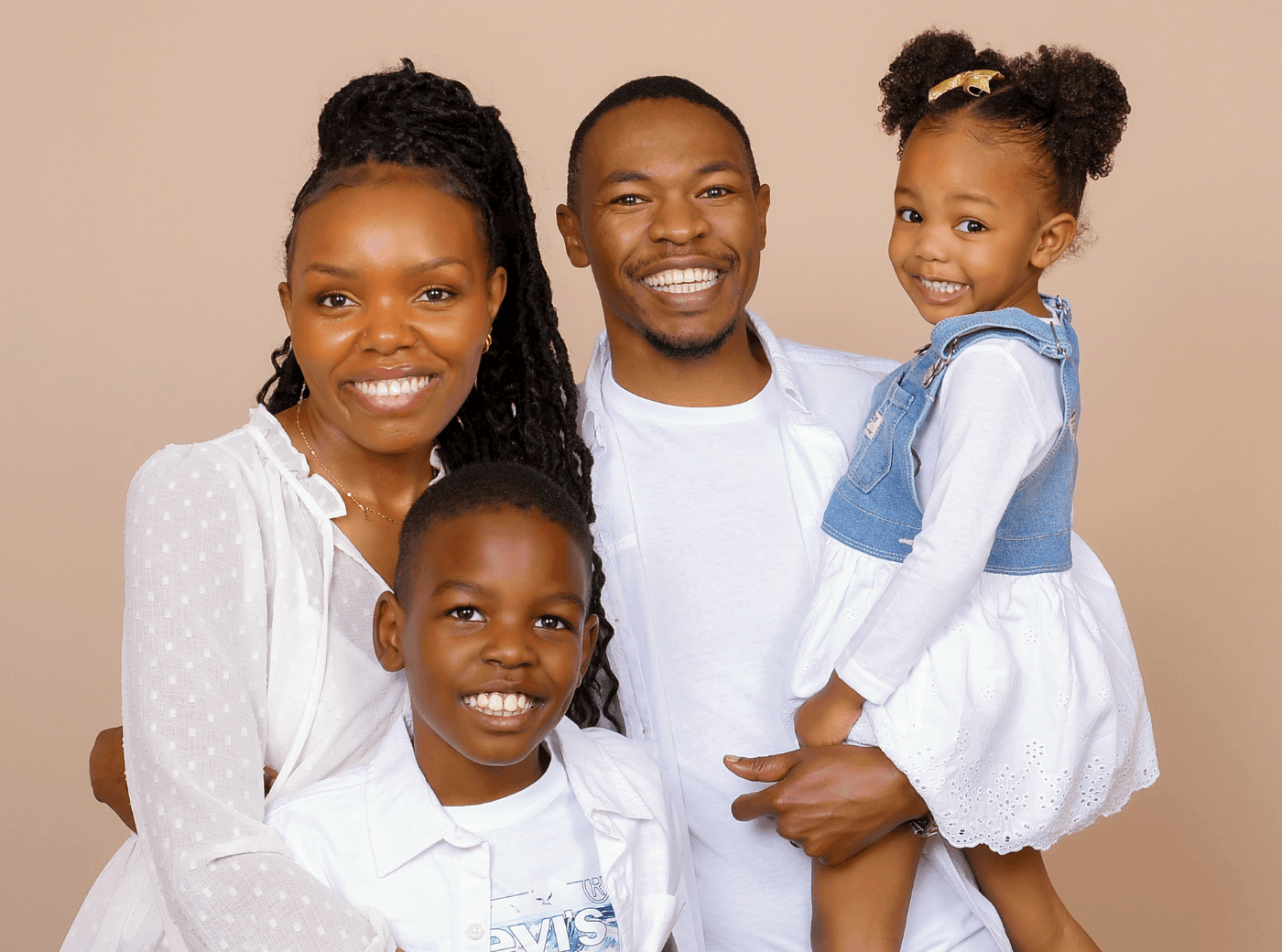 Family of 4 smiling for family pictures at JCPenney Portraits.