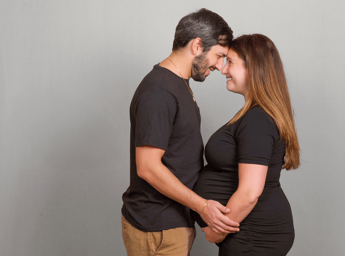 Couple with their foreheads touching for professional maternity pictures.