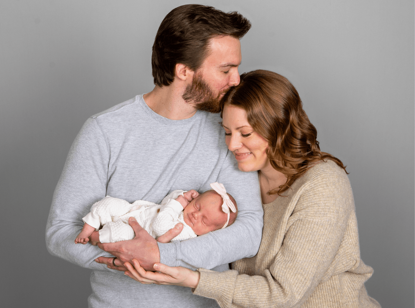 Family of three taking newborn pictures at JCPenney Portraits.