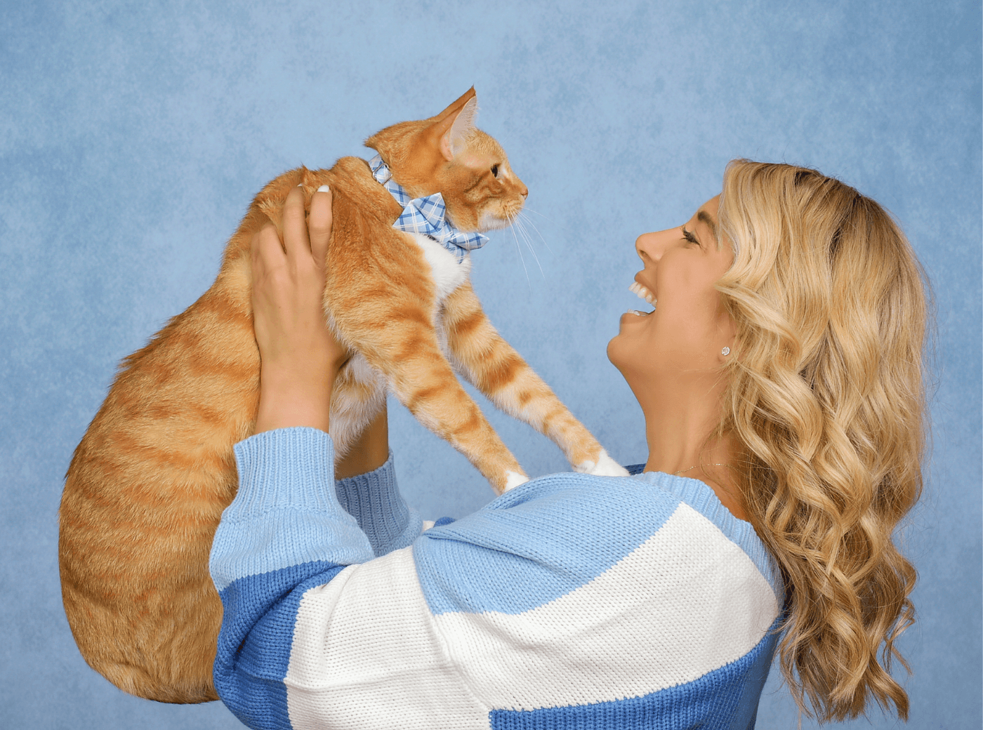 Woman holding her orange cat for professional pet photography.