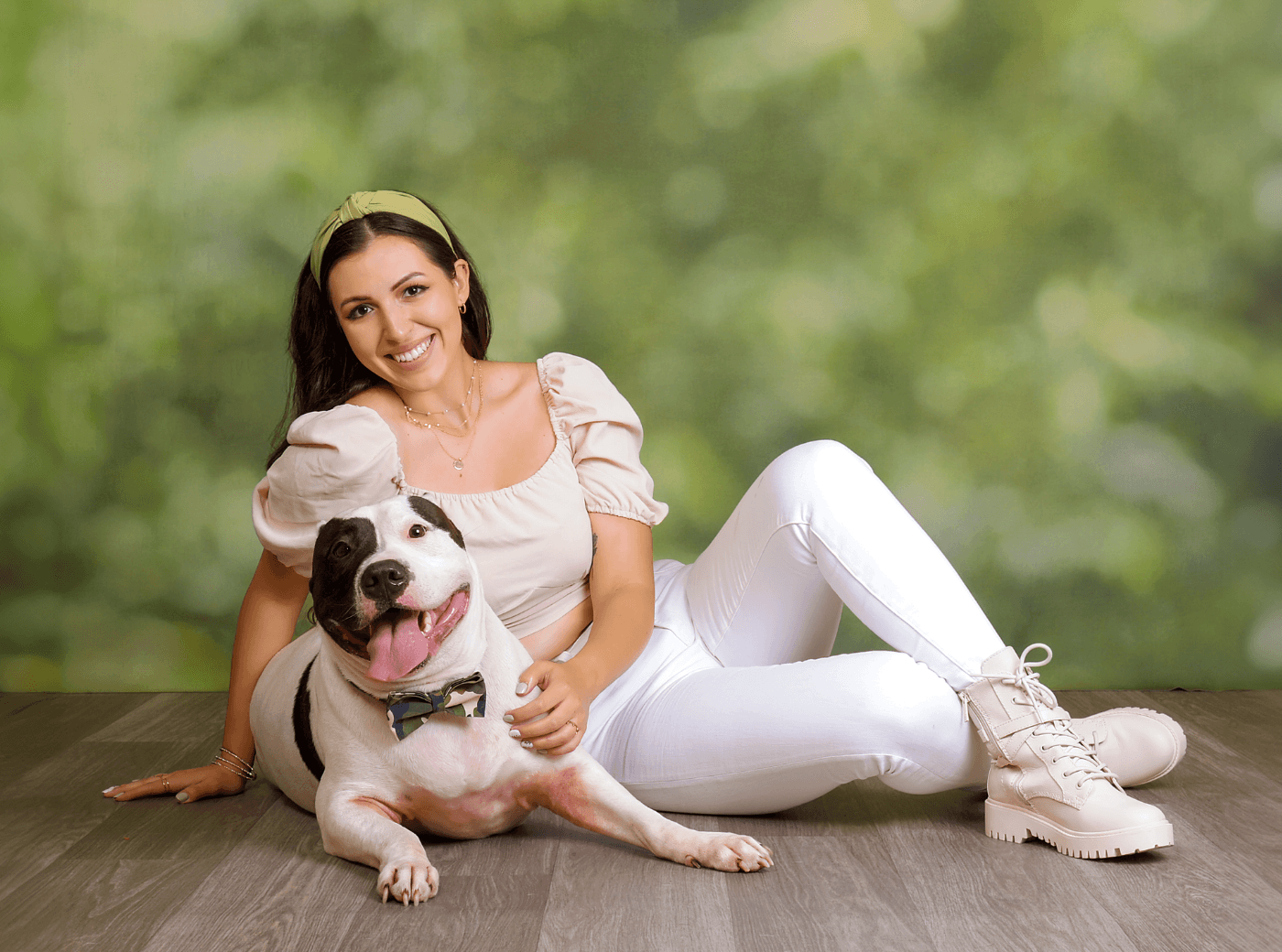Woman and her dog posing on the floor for professional pet pictures.