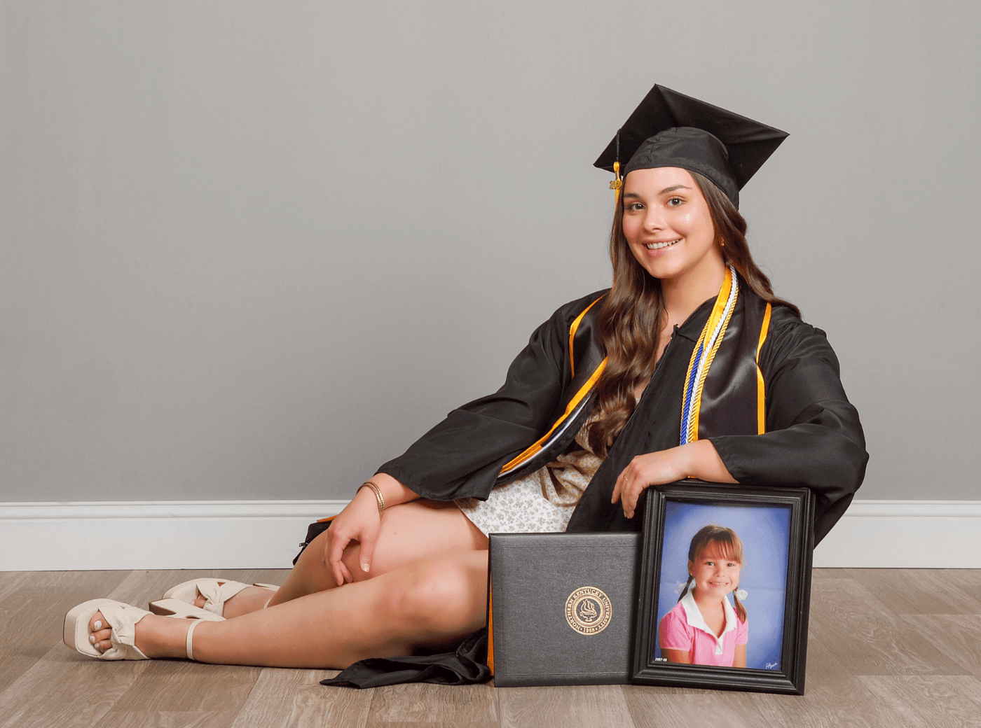 Graduating senior posing with a Lifetouch photo for professional graduation pictures at JCPenney Portraits.