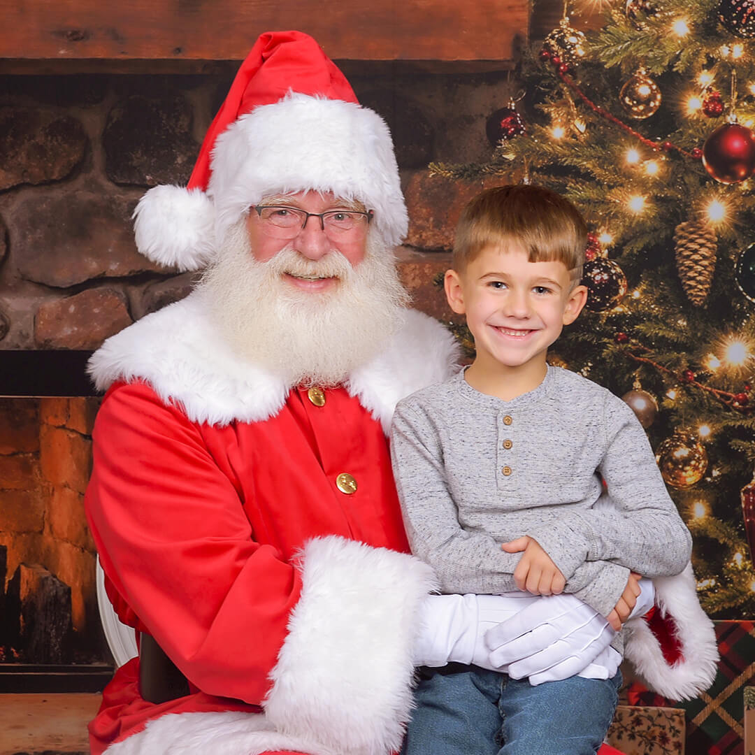 Boy sitting on Santa's lap for a santa photoshoot at JCPenney Portraits.