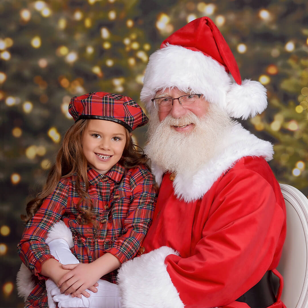 Girl sitting on Santa's lap for a Santa photoshoot at JCPenney Portraits.